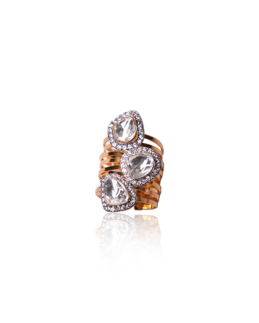 Gold Amruta Ring from Vasundhara, adorned with three kundan stones surrounded by diamonds, placed on white background.