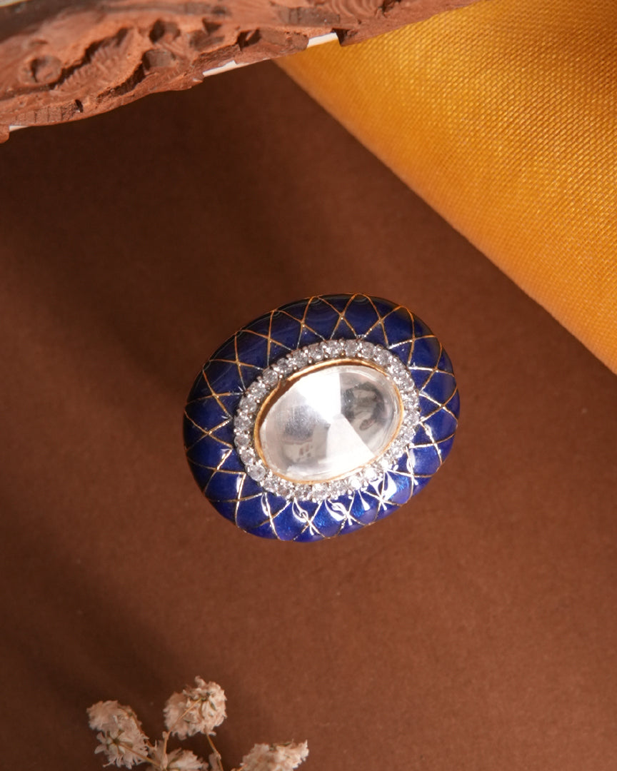 Saanjh Ring by Vasundhara in rich blue enamel with crystal-embellished mirror stone, set against earthy tones and fabric.