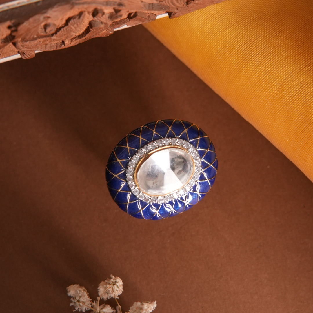 Saanjh Ring by Vasundhara in rich blue enamel with crystal-embellished mirror stone, set against earthy tones and fabric.