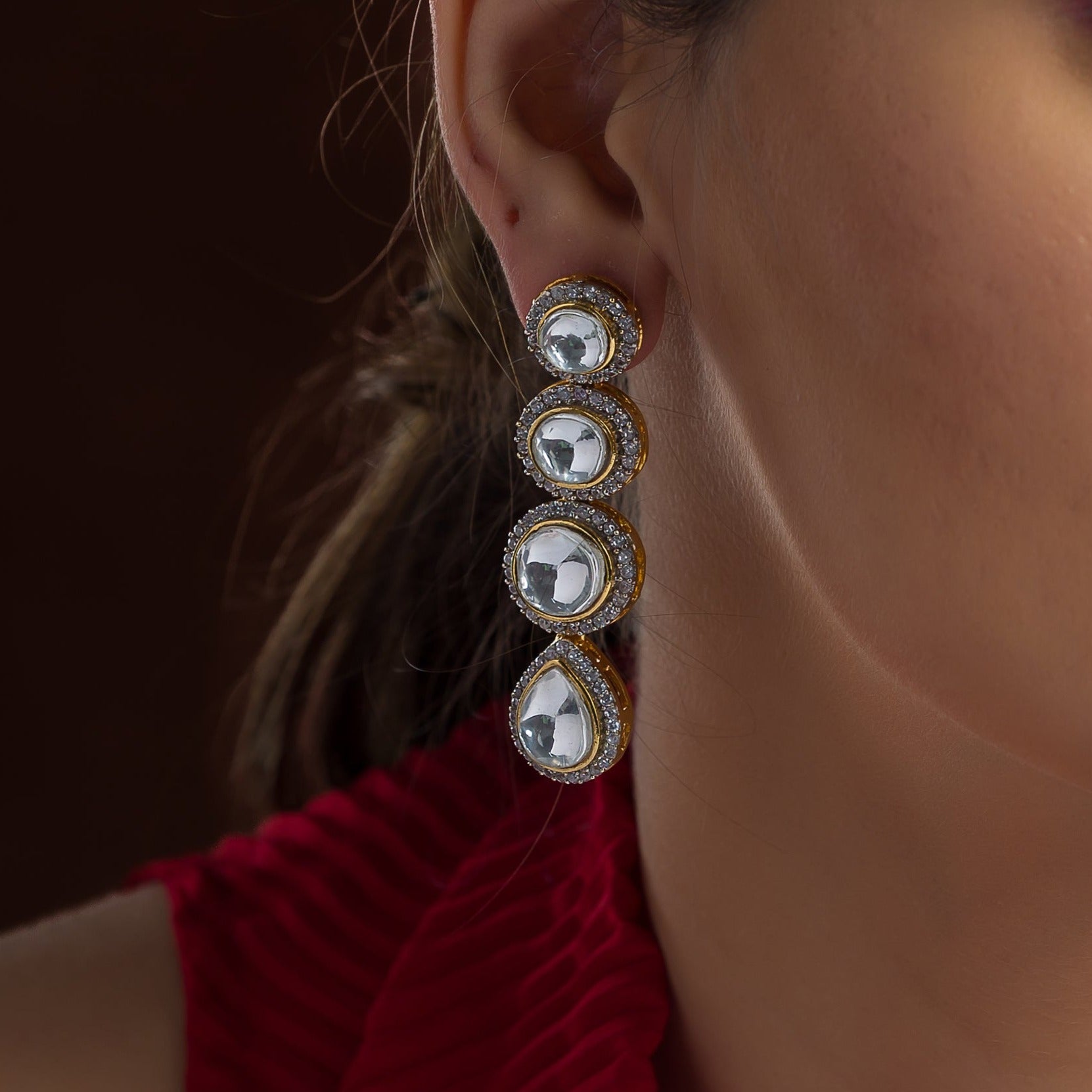A woman's face is shown with a Nadine Earring