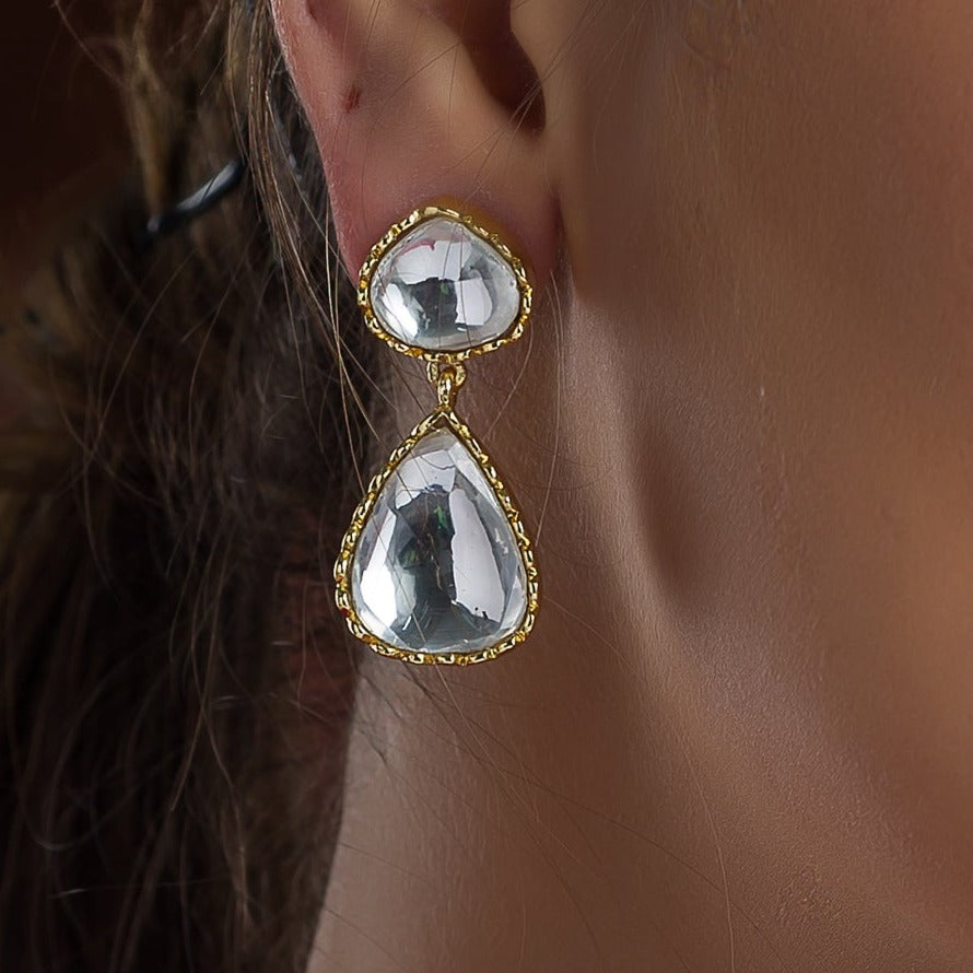A woman wearing Rahma Earrings from Vasundhara on her right ear is featured 