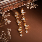 Mithira Earrings are displayed on a beautiful brown backdrop with flowers 