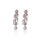 Elegant Prisha Earrings by Vasundhara showcasing cascading kundan stones and crystal detailing, placed on a white backdrop.