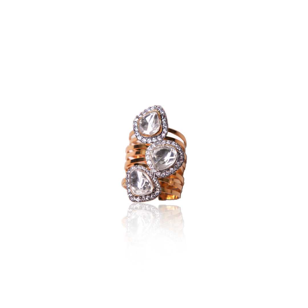 Gold Amruta Ring from Vasundhara, adorned with three kundan stones surrounded by diamonds, placed on white background.