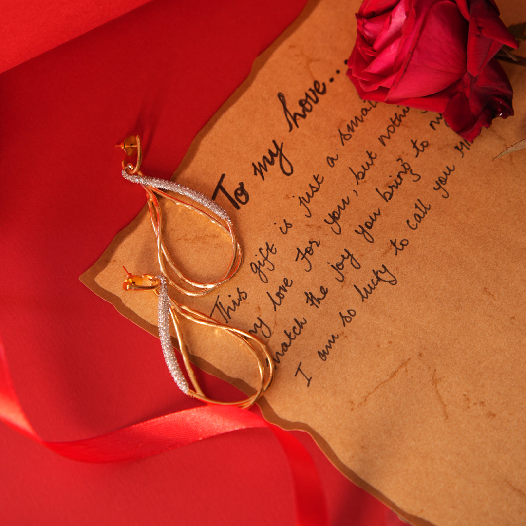 Vasundhara's Premier Earrings are displayed on a red romantic background