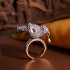 Sharanya Ring by Vasundhara, bird-shaped design with kundan and diamond accents, styled on a rich brown and gold backdrop.