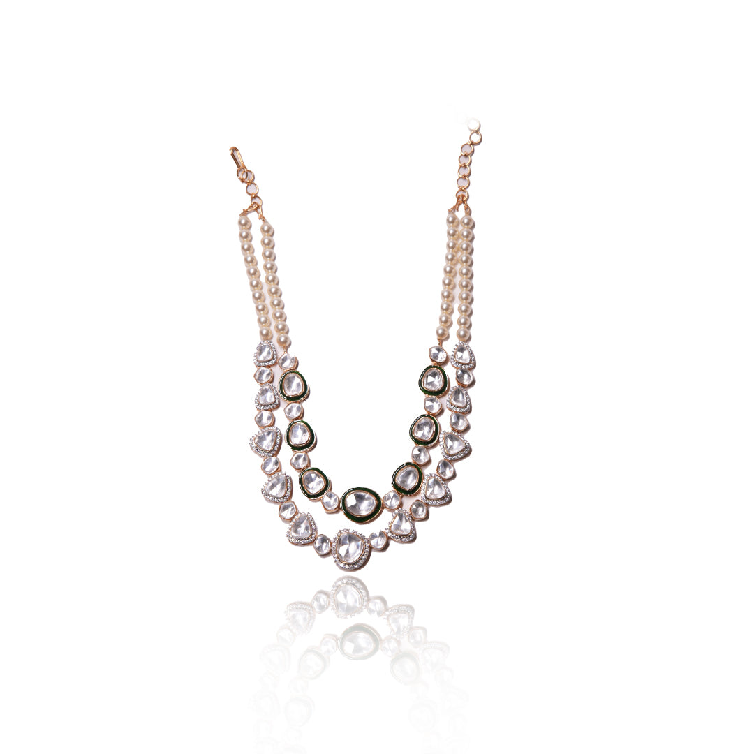 The Prisha Necklace by Vasundhara showcases pearls and kundan stones, styled on a woman’s neck in soft lighting.