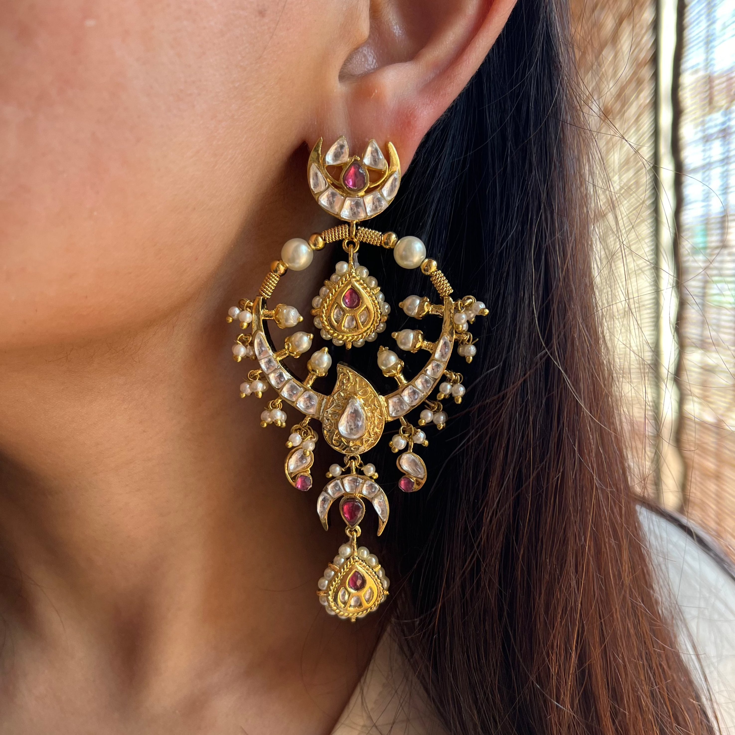 Woman styled in Vasundhara Masuma Earrings, intricate gold, pearl, and kundan design with pink gemstones for ethnic charm.