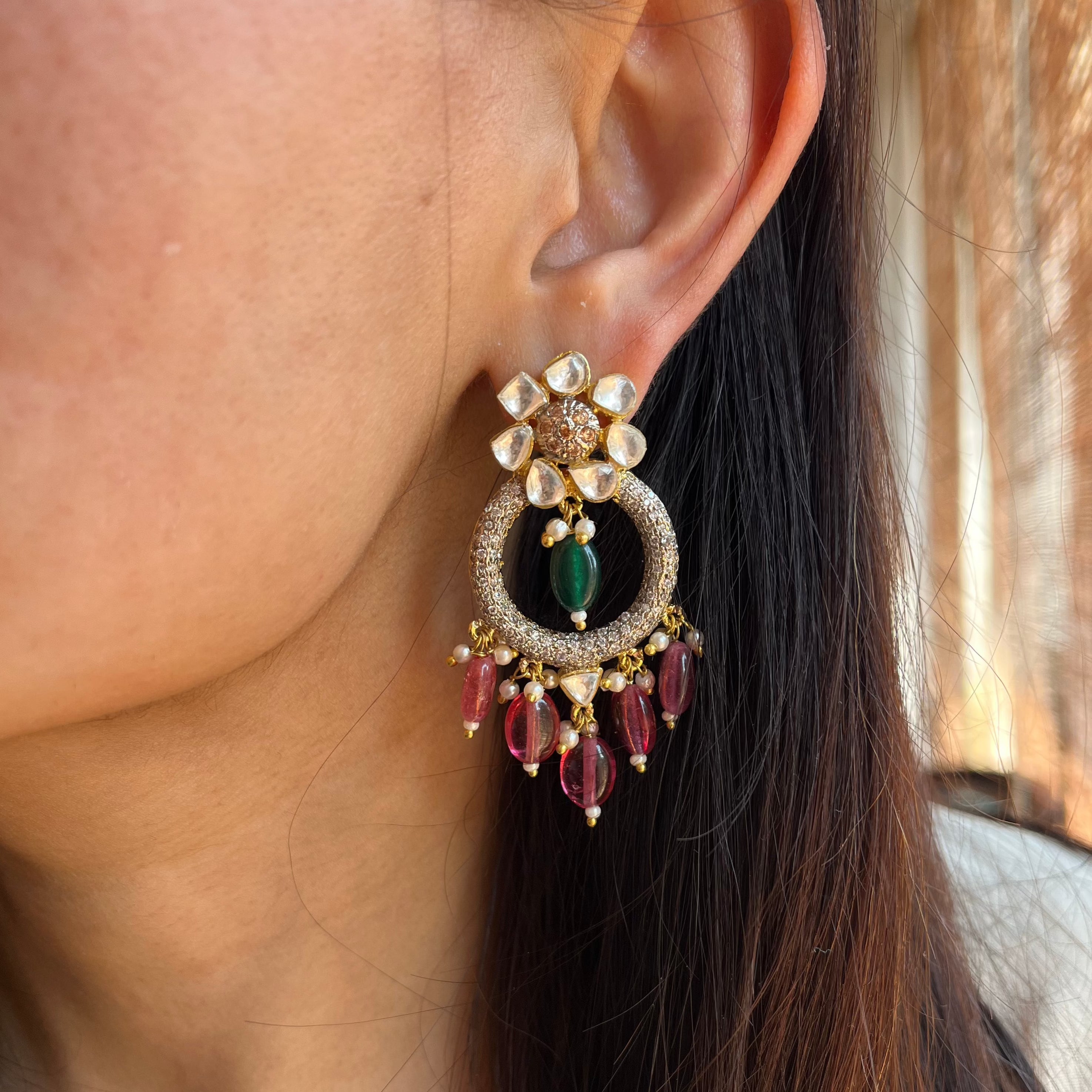 A girl is wearing Nadira Earrings on the left ear 