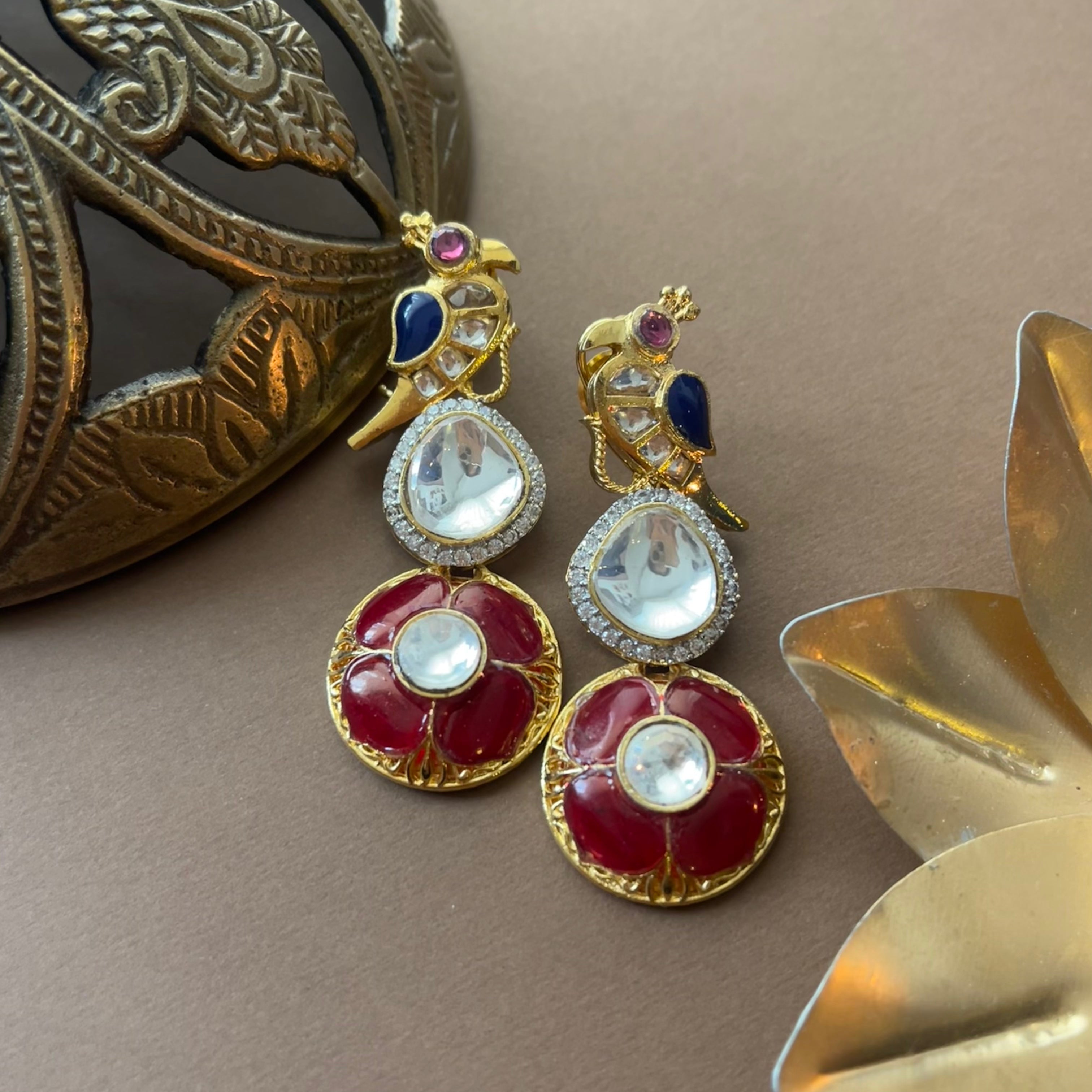 Indira Earrings of Vasundhara are shown on a deisgner background 