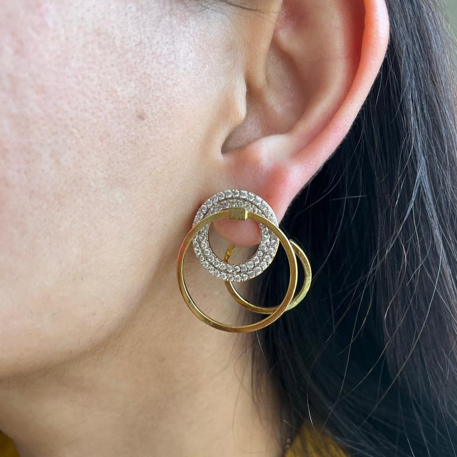 3 hoops of gold and stones are clearly visible on an ear