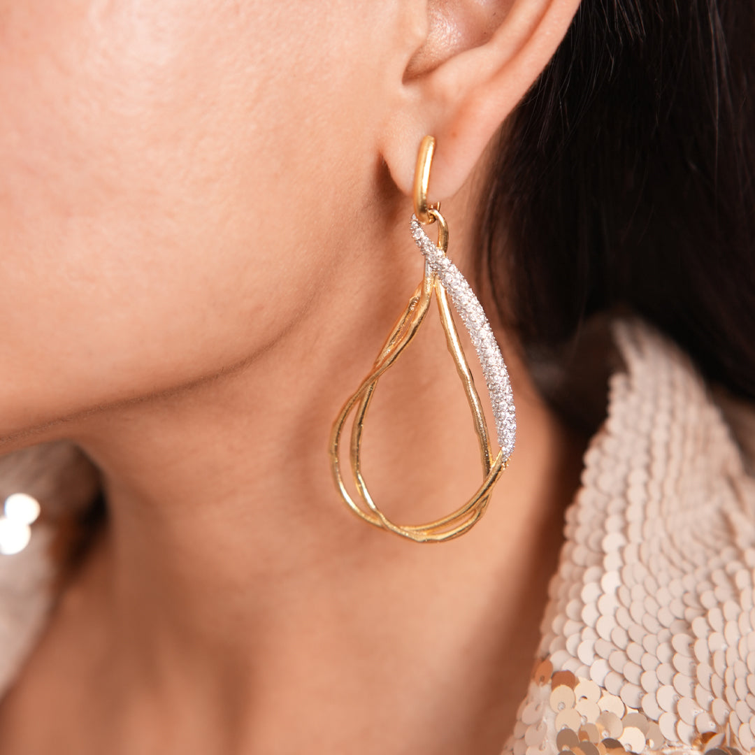 The model is posing with Vasundhara's Premier Earrings on her left ear 
